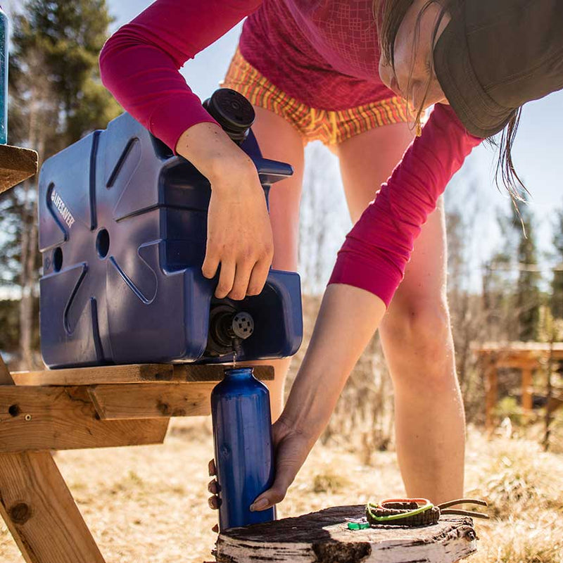 Cargue la imagen en el visor de la galería, Person camping using the LifeSaver water purification Jerrycan to fill a bottle of clean water