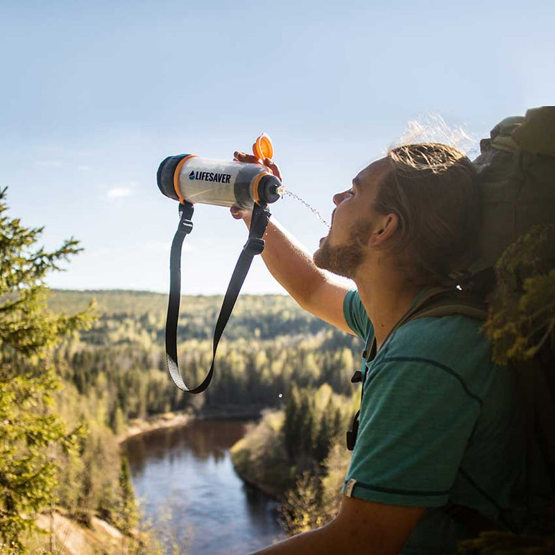 Load image into Gallery viewer, Man in the outdoors of Sweden drinking clean water from LifeSaver water purifier bottle