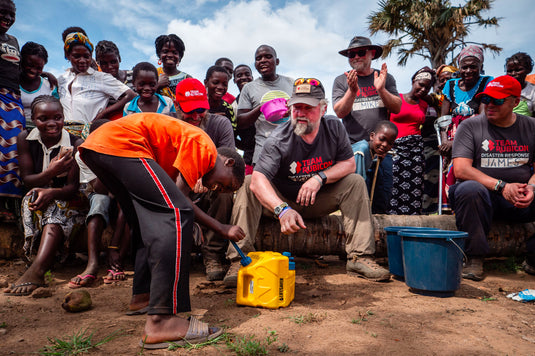 Team Rubicon disaster response teaching villagers how to use a LifeSaver Cube to purify their water