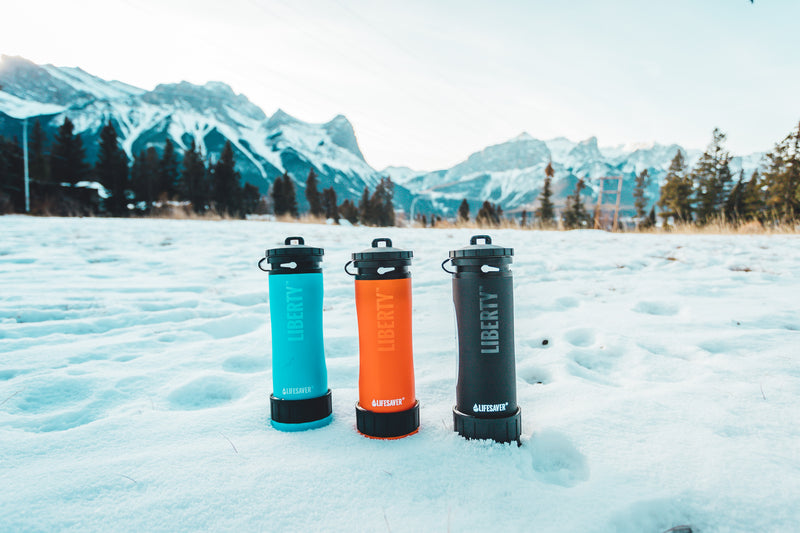 Cargue la imagen en el visor de la galería, Liberty water bottles in a snowy mountainside
