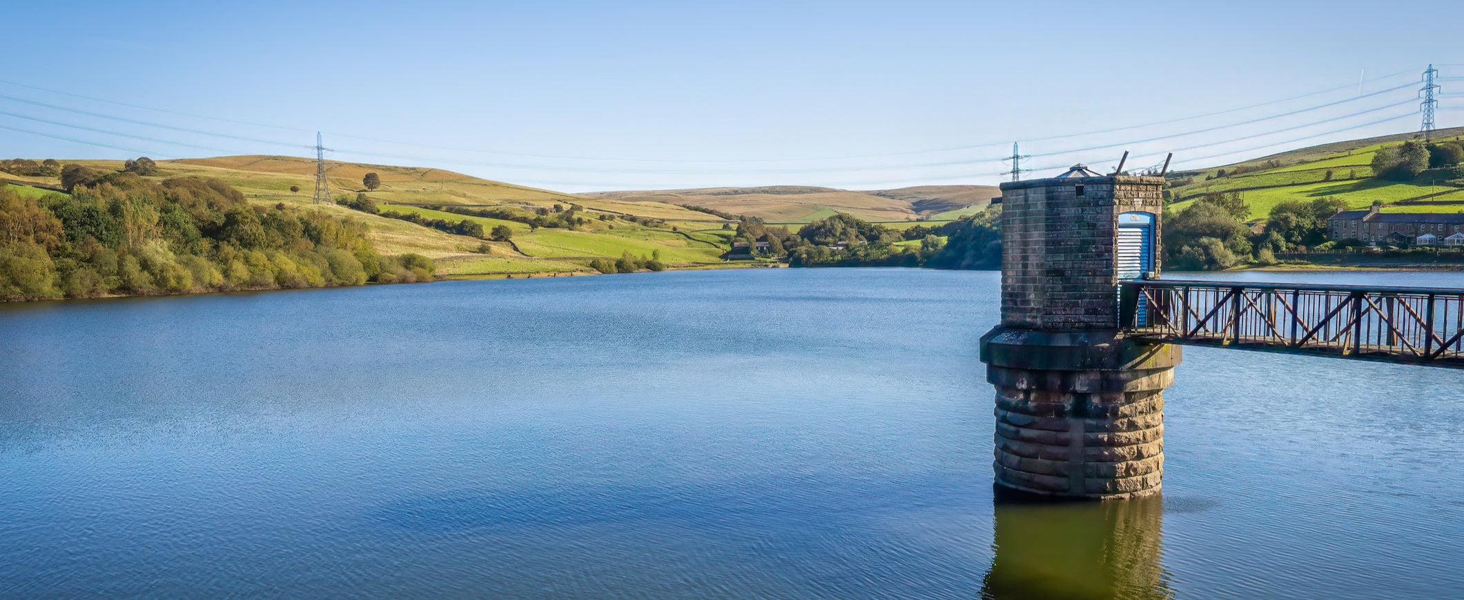 Reservoir with a dam and surrounding green landscape